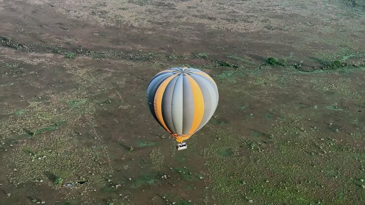 Hot air balloon flies over the savannah in Serengeti National Park in Tanzania.