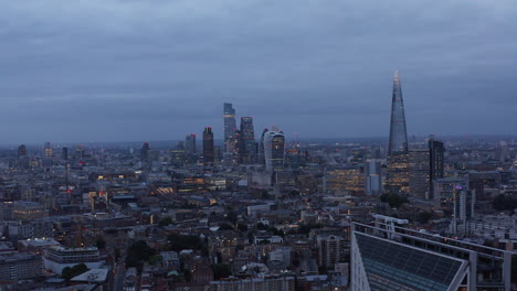 Dia--Und-Schwenkaufnahmen-Von-Hohen-Bürogebäuden-Im-Geschäftszentrum-Der-Stadt.-Panoramablick-Auf-Das-Stadtbild-Mit-Wolkenkratzern-In-Der-Abenddämmerung.-London,-Vereinigtes-Königreich