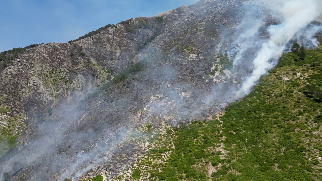 Scorched forest and mountain caused by wildfire burning through the landscape