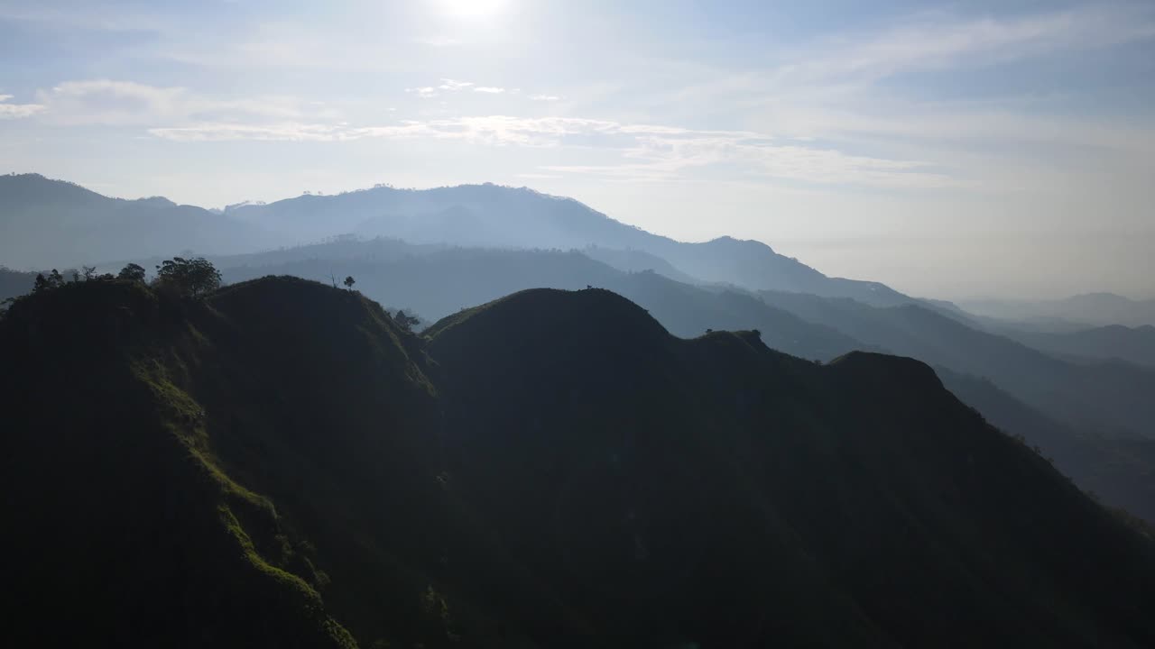 Rekaman drone udara bergerak maju di atas Puncak Little Adam di Sri Lanka dengan matahari terbit di latar belakang