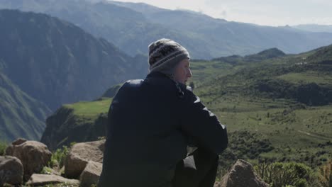 Hombre-Caucásico-Sentado-En-El-Acantilado-Del-Cañón-Del-Colca-En-Perú-Y-Disfruta-Del-Espectacular-Paisaje-Sobre-El-Cañón