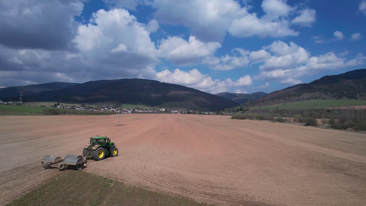 큰 토양 필드를 평평하게 하기 위해 롤러를 운반하는 트랙터의 설치자 안테나