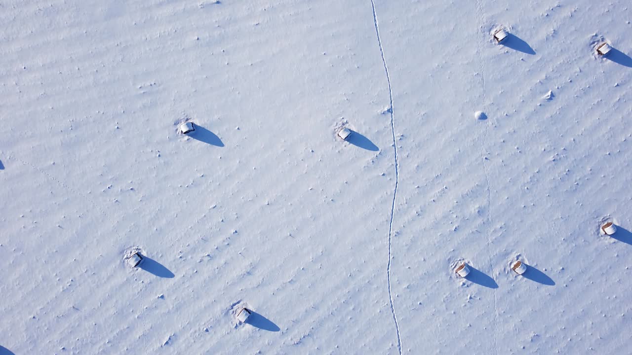 눈으로 덮힌 건초 롤 조감도 낮은 햇빛 긴 그림자
