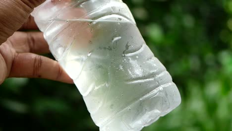 hand holding a cold water bottle