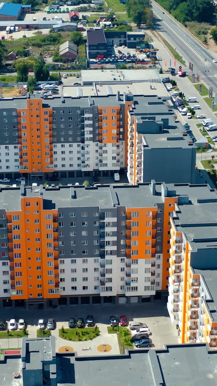 New residential complex from above. Multi-storey buildings for city residents in the new area with parking places. Aerial view. Vertical video