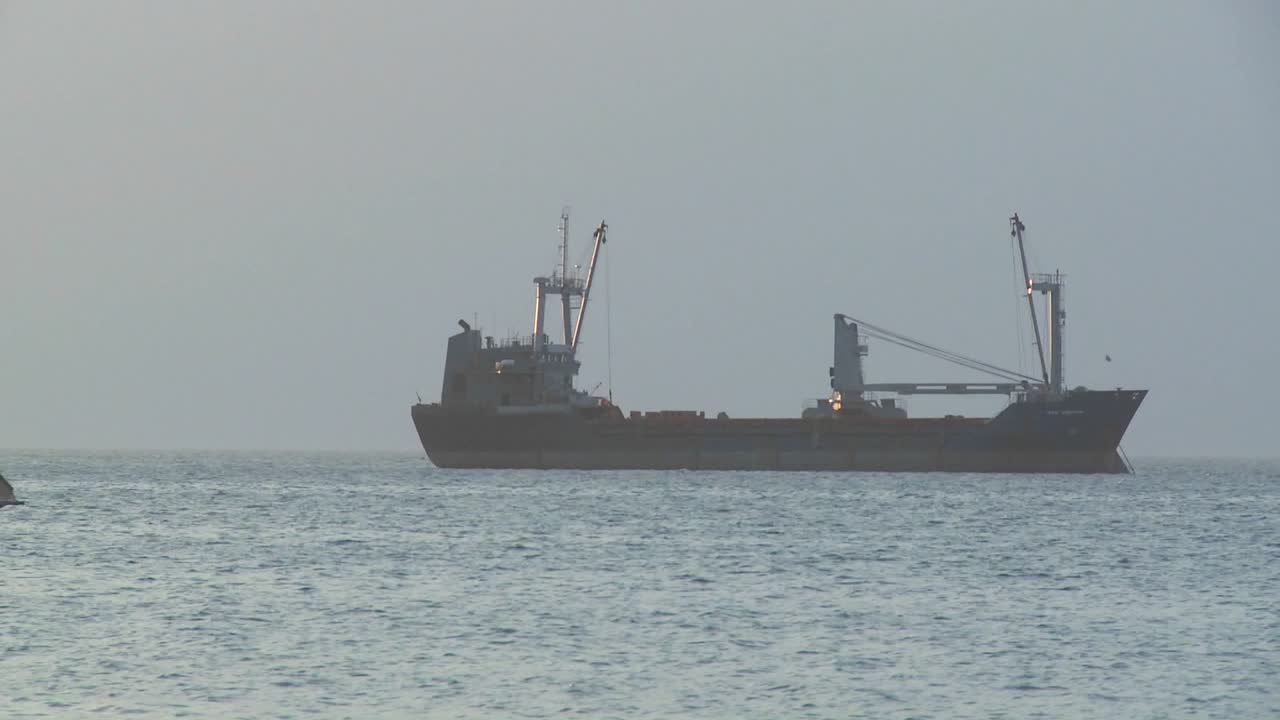 잔지바르 연안에서 현대식 화물선 화물선을 항해하는 다우 범선