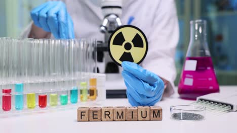 scientist working with fermium in a laboratory, holding a radioactivity symbol