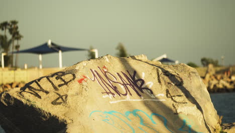 Static-view-of-a-boy-skating-on-his-skate-board-on-the-bank-of-San-Gabtiel-river,-California,USA-at-sunset