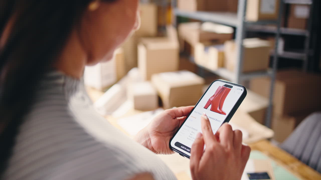 Donna che naviga in un negozio online sullo smartphone in un ambiente di magazzino