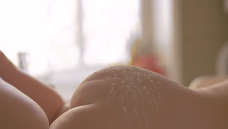 madre aplicando polvo para bebés a la piel del niño