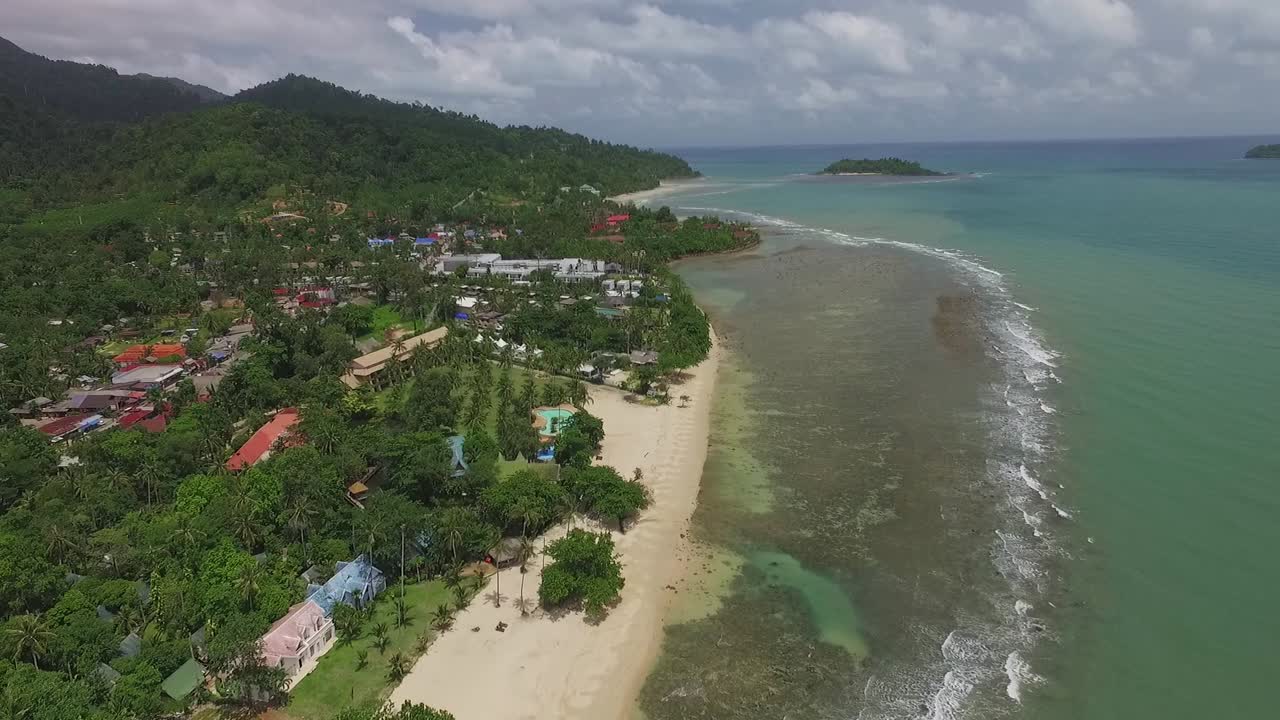 vista aérea sobre los centros turísticos costeros de la isla tropical de koh chang que avanzan hacia una exuberante cordillera verde