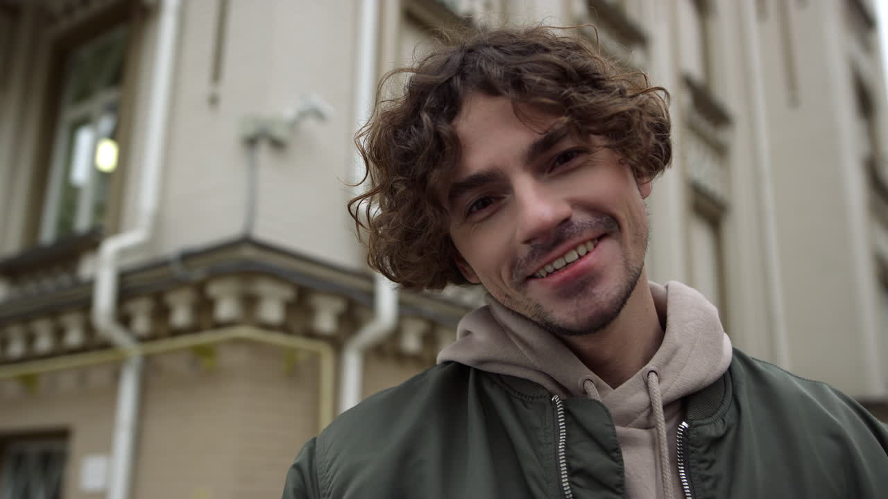 Cheerful man feeling happy outdoor. Closeup joyful guy enjoying city center.