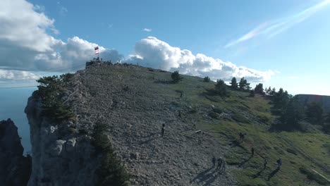 aerial view of mountain summit with flag and people