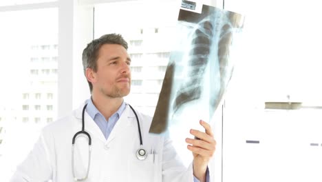 Doctor-studying-an-xray-and-looking-at-camera