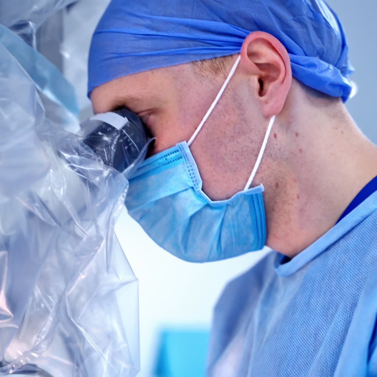 Closeup of a surgeon with operating microscope. Health care concept. Medics in scrubs.