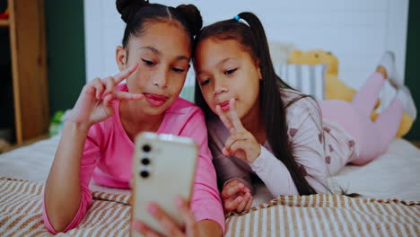 girls taking selfies on the bed