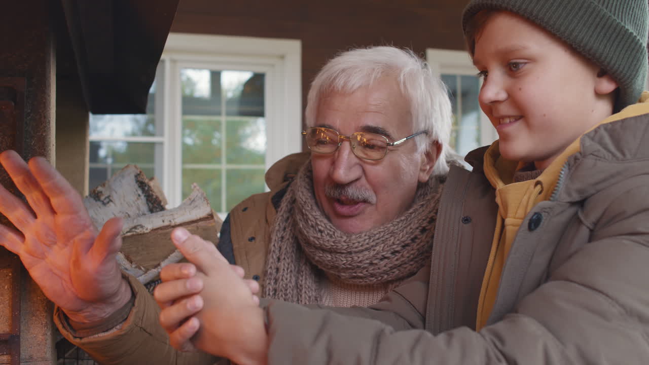 Child and His Granddad Warming Hands by Fire