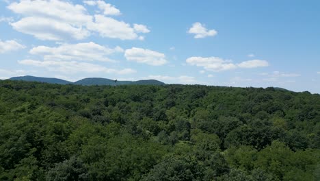 Aerial-shot-of-the-Hills-of-Börzsöny,-Hungary-with-a-Water-Tower-Sphere-in-the-forest