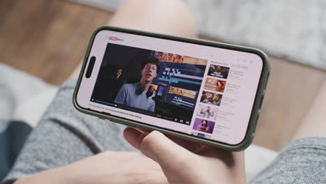 persona viendo un video de youtube en su teléfono inteligente