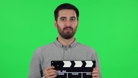 man holding a clapperboard in a studio setting