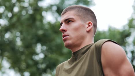 Focused-male-athlete-effort-on-his-face-trains-concentrated-push-ups-in-outdoor-park-facility