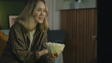 mujer viendo la televisión con palomitas de maíz