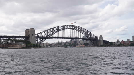 turbulent ocean under sydney harbour bridge on stormy, rainy overcast day