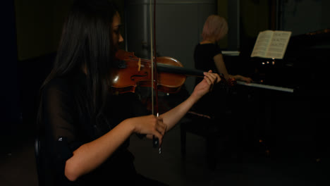 two women playing a violin and piano