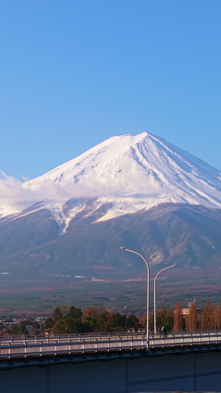 Aerial drone view of the Kawaguchiko-Ohashi bridge near the Fujikawaguchiko town in Japan with Mount Fuji on the background. Vertical