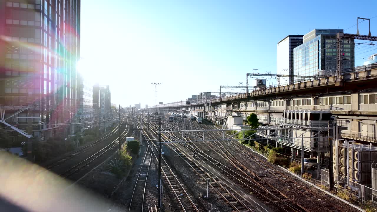 A vibrant urban railway network viewed through a fence during morning light