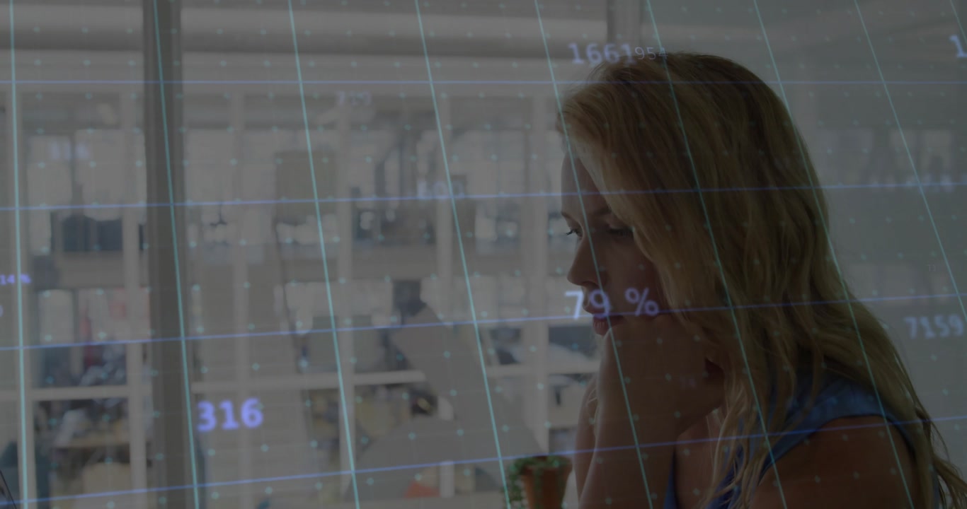 In ufficio, donna che analizza dati con grafici animati sullo schermo del computer.