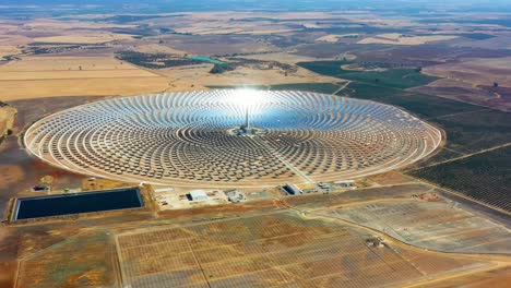 photovoltaic solar panels power plant. thermosolar power plant, a center of solar farm surrounded by fields - panorama view with a drone - environment concept