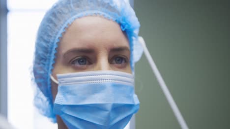 Female-caucasian-doctor-wearing-protective-clothes-reparing-covid-swab-test-for-patient