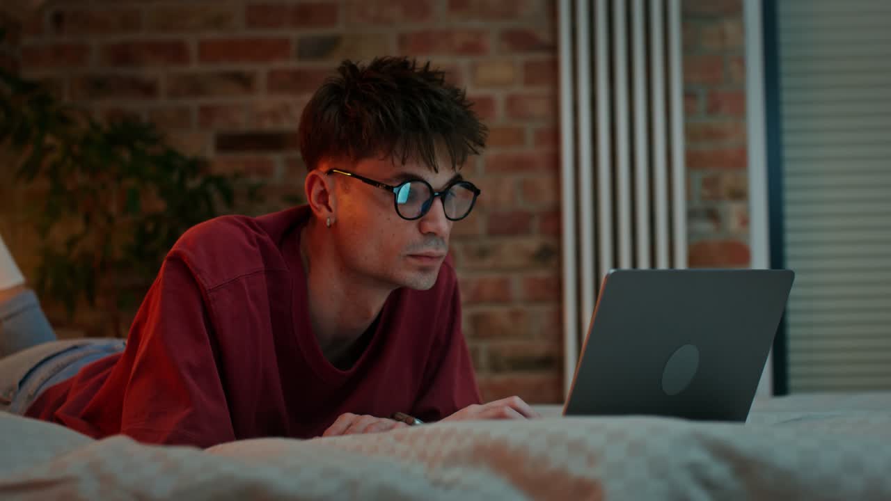 Man Working on Laptop in Bedroom