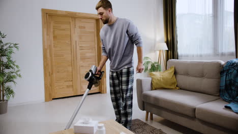 man using vacuum cleaner in his living room