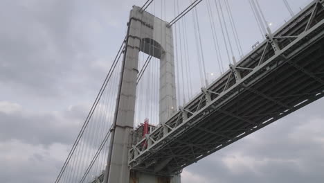 drone shot looking up at the verrazzano-narrows bridge on an overcast day. shot in new york city