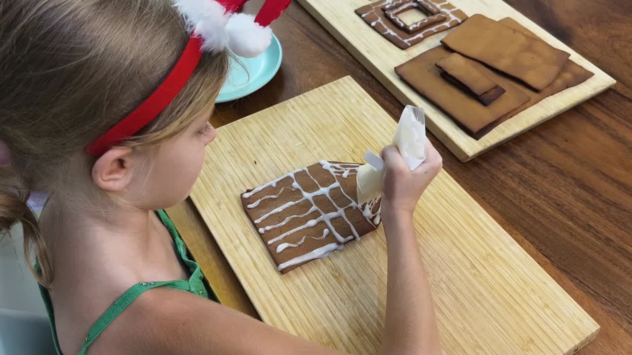 niño decorando una casa de pan de jengibre