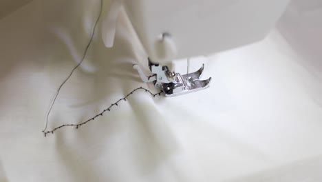 a seamstress sewing a black decorative stitch onto white fabric