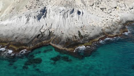 aerial push in shot of beautiful turquoise water and white rocks