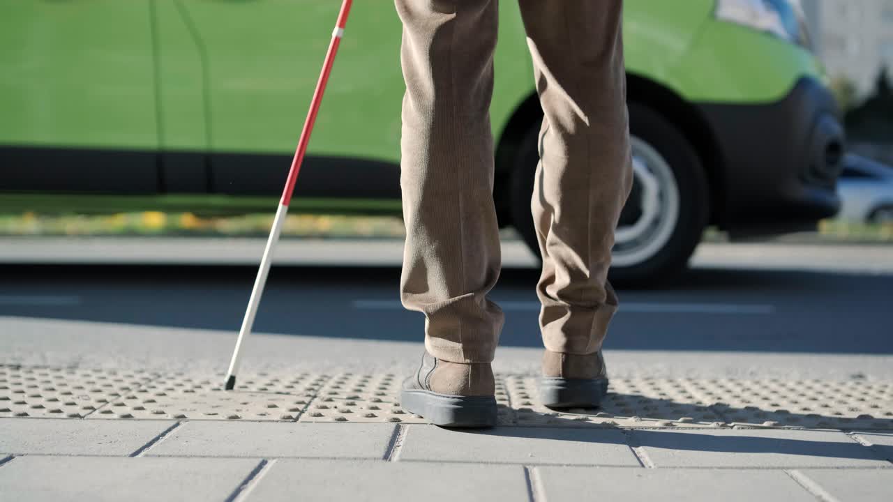 バス停でバスを待っている盲目な男