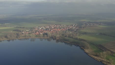 Drone-aerial-of-the-typical-german-village-Seeburg-located-at-the-Seeburger-See-on-a-beautiful-Sunday-morning