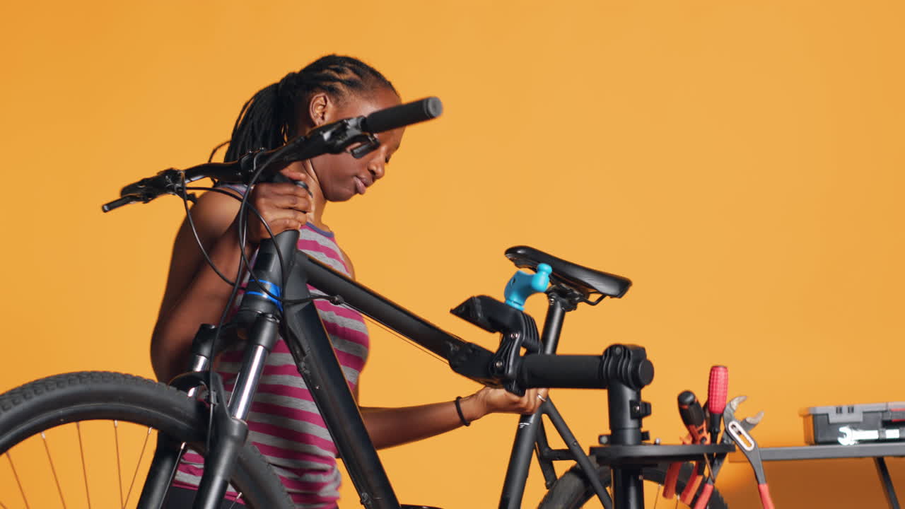 행복 한 수리사 는 부품 을 수리 하기 전 에 수리 스탠드 에 자전거 를 고정 시키고 있다