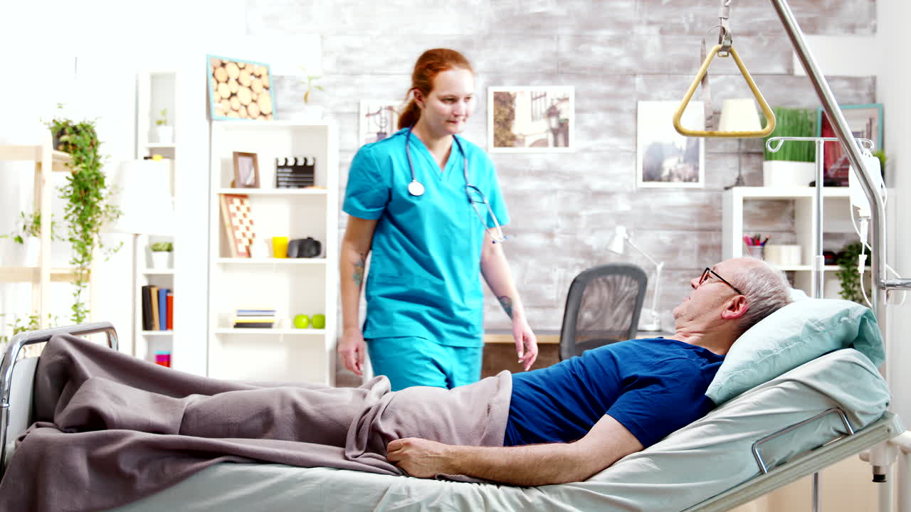 enfermera ayudando a un anciano discapacitado enfermo que yace en una cama de hospital