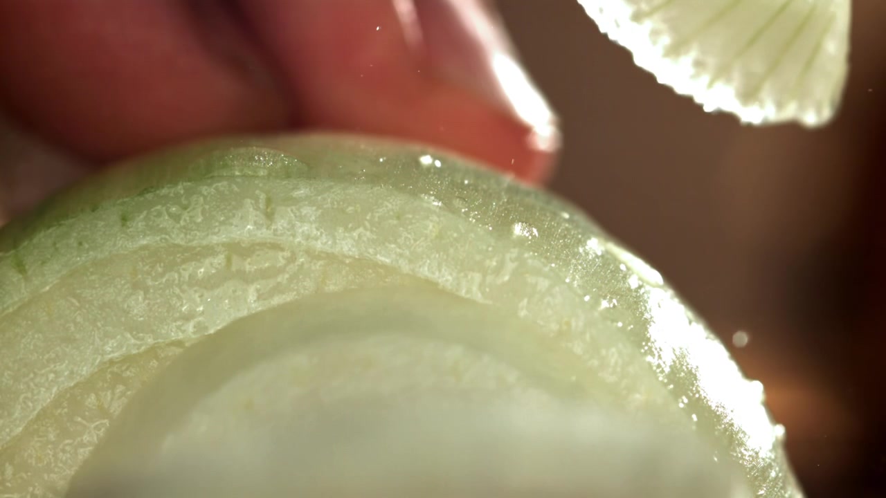 Close-up Slow Motion of a Knife Slicing a Fresh Onion