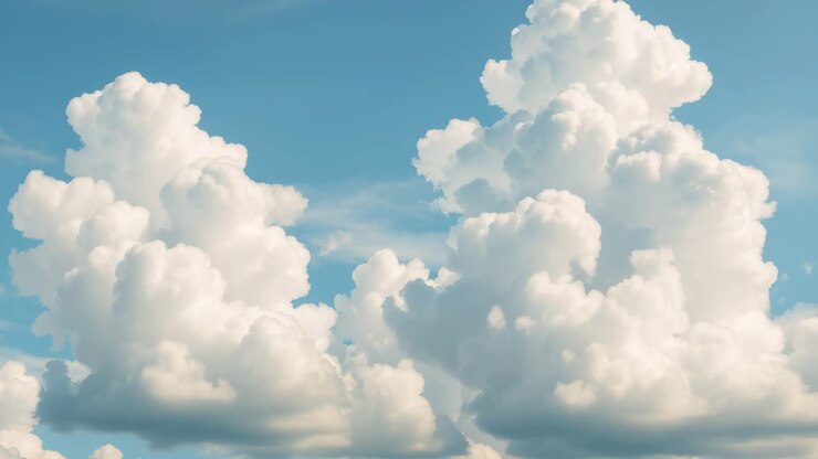 A serene video of fluffy white clouds against a blue sky, captured from a low angle