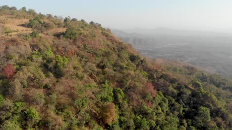 Drone-shot-rising-over-a-ridge-to-reveal-dry-hills-in-the-Deccan-plateau-Maharashtra-India