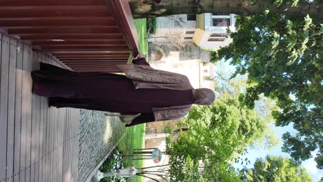 woman in purple abaya looking at a lush garden
