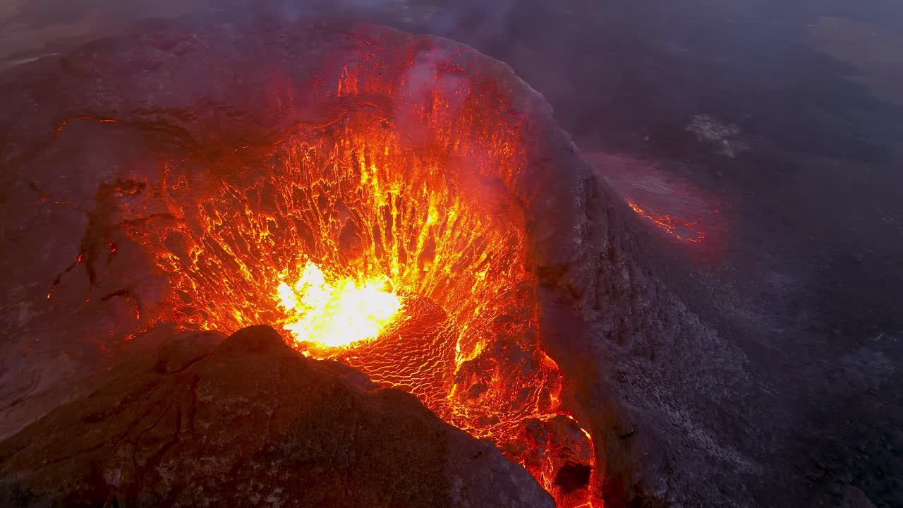 increíble vista aérea de drones nocturnos del cráter del volcán activo volcán fagradalsfjall con rocas de lava cayendo en islandia