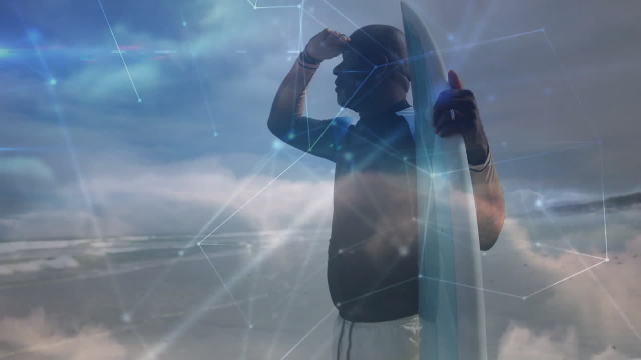 Older man scanning horizon while holding surfboard, displaying digital network technology