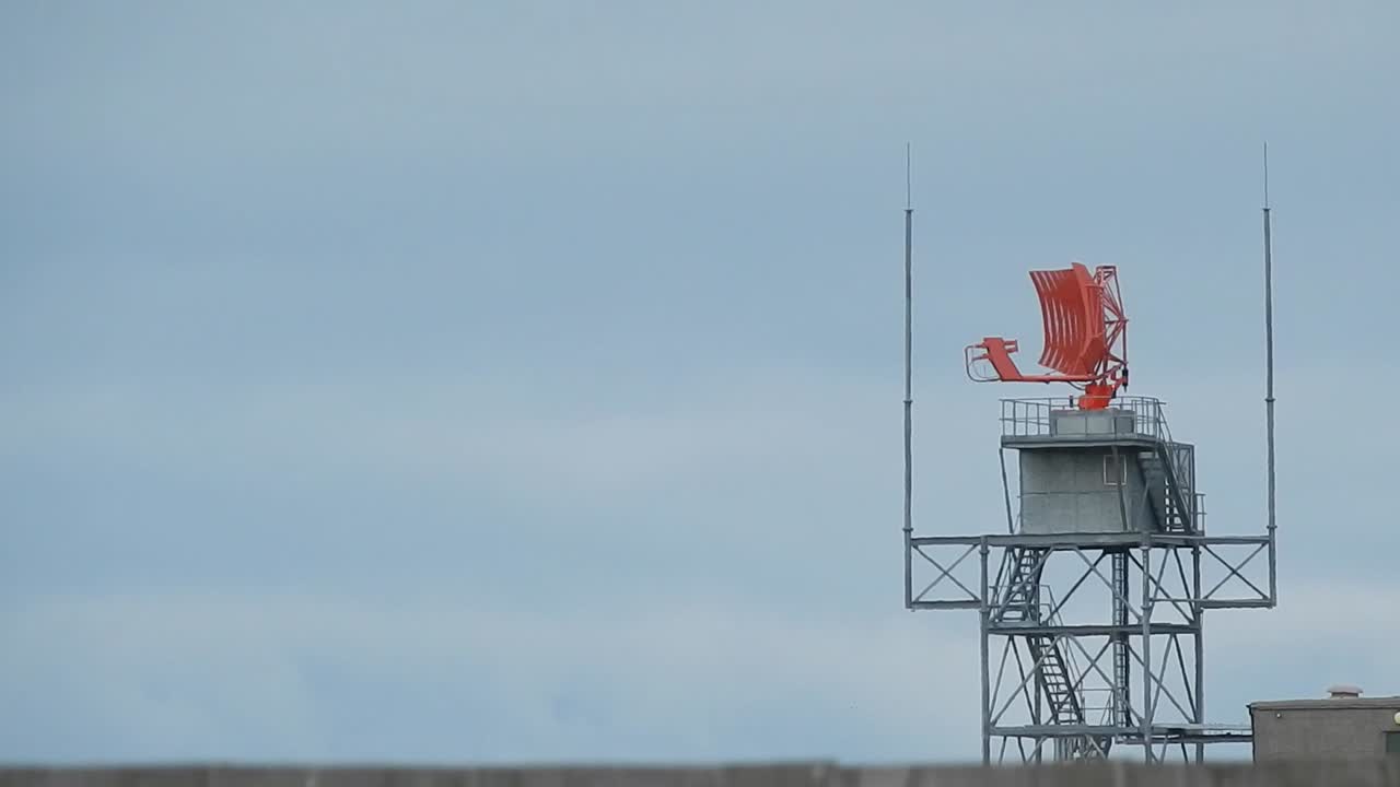 Air traffic control radar tower rotating across Welsh valley airport in Holyhead